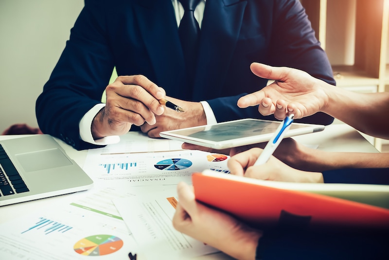 Business discussion around a tablet and planning documents